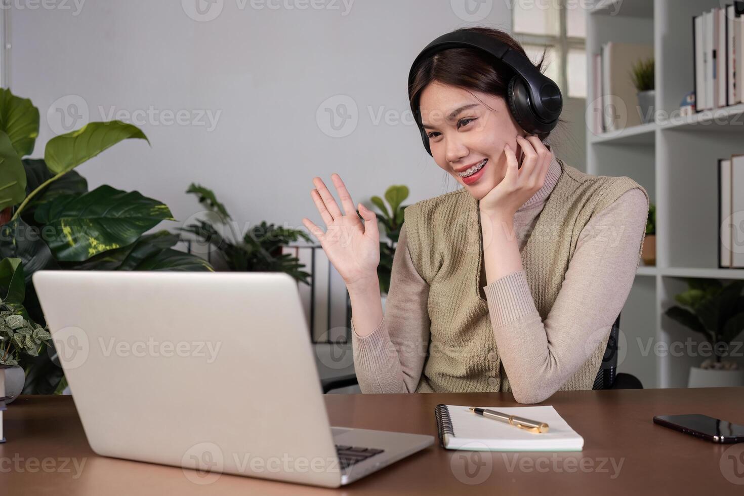 Asian college student sit at home studying online using a calling program on their laptop. photo