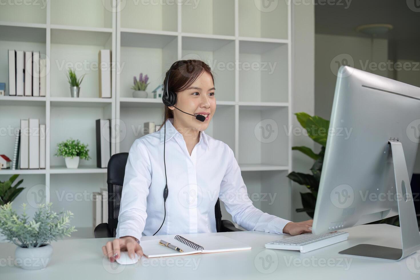Call center agents wear headphones to talk to customers. Provide consultation via online channels on laptops photo