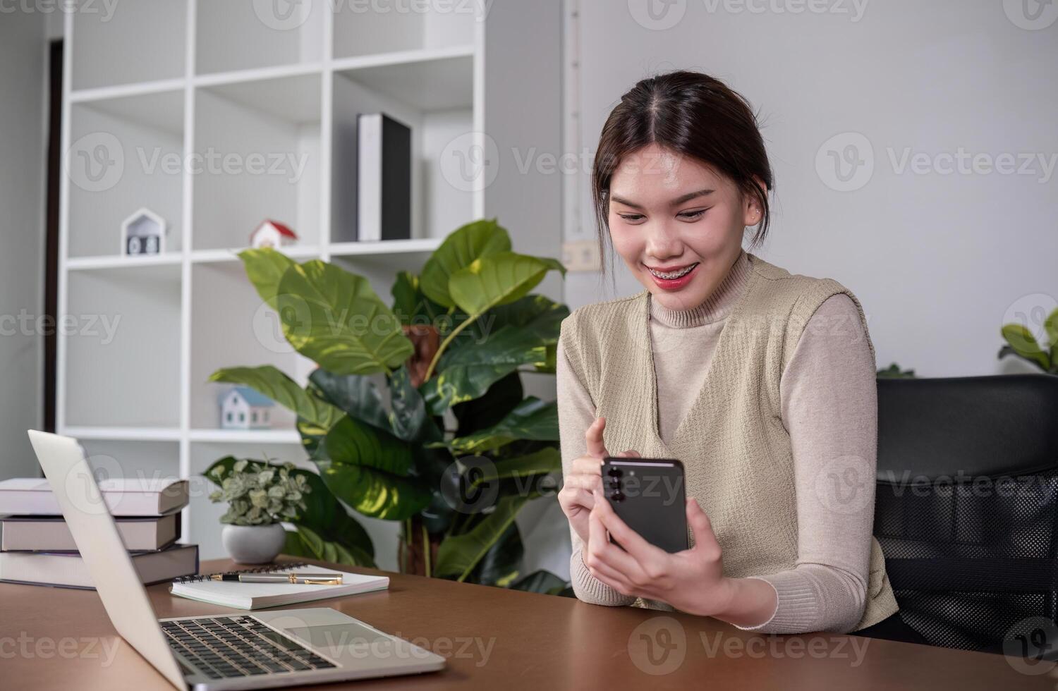 Asian college student sit at home studying online using a calling program on their laptop. photo