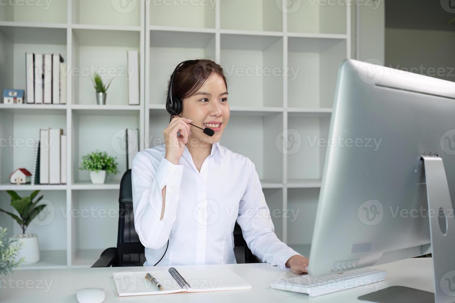 Call center agents wear headphones to talk to customers. Provide consultation via online channels on laptops photo