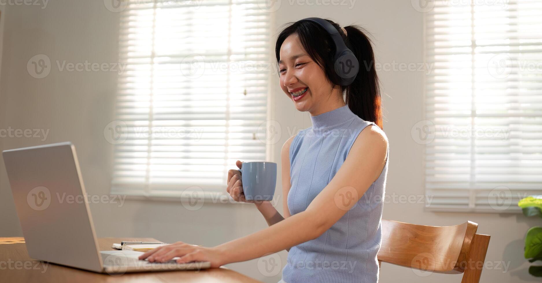 Asian college student sit at home studying online using a calling program on their laptop. photo