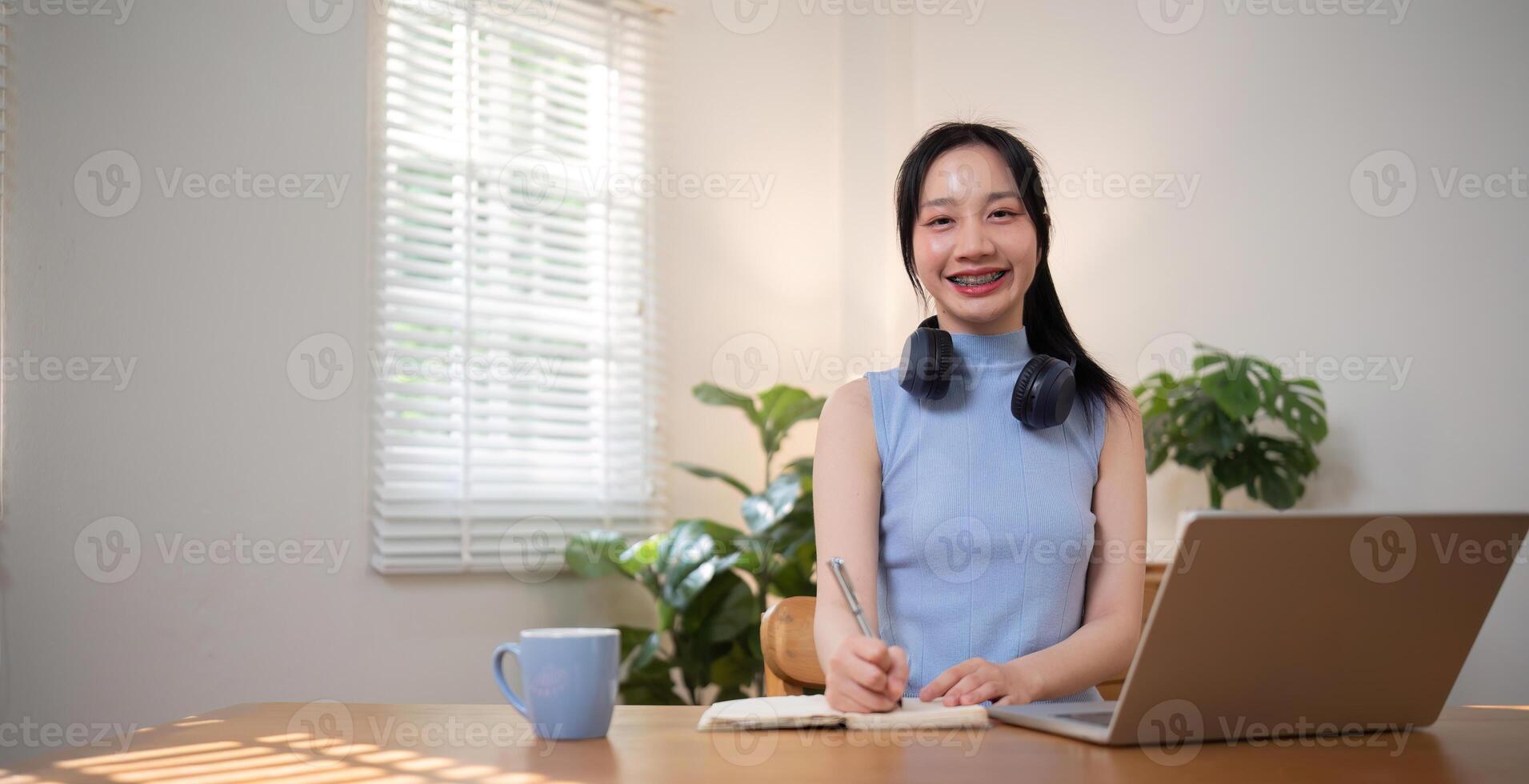 Asian college student sit at home studying online using a calling program on their laptop. photo