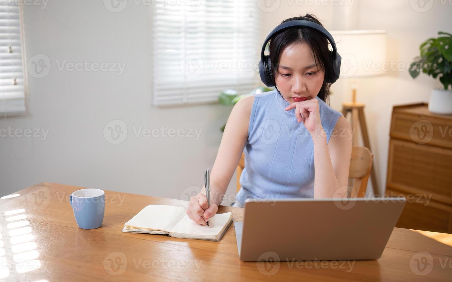 Asian college student who is bored Sitting in front of a laptop studying online through a calling program on a laptop at home. photo