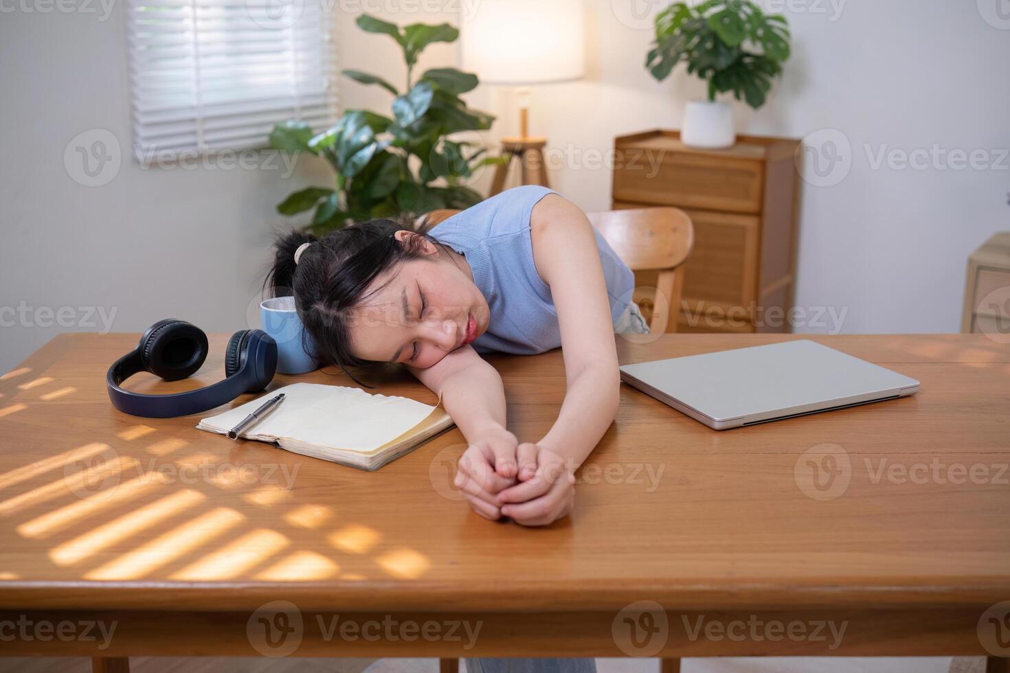Asian college student who is bored Sitting in front of a laptop studying online through a calling program on a laptop at home. photo