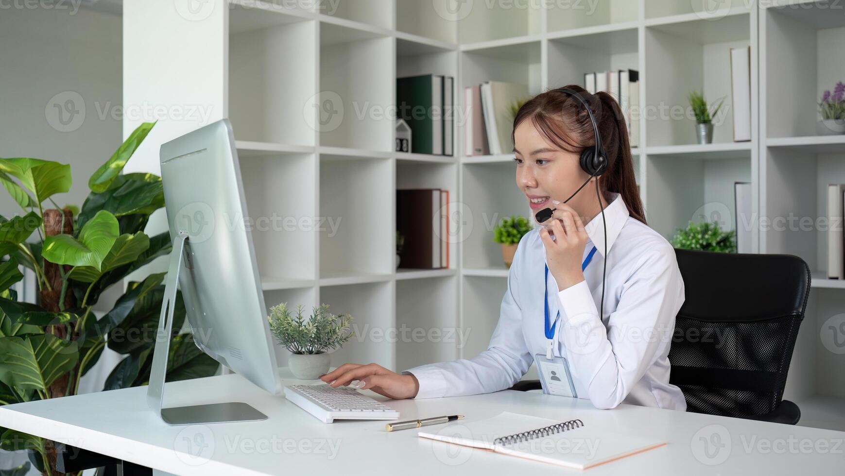 Call center agents wear headphones to talk to customers. Provide consultation via online channels on laptops photo
