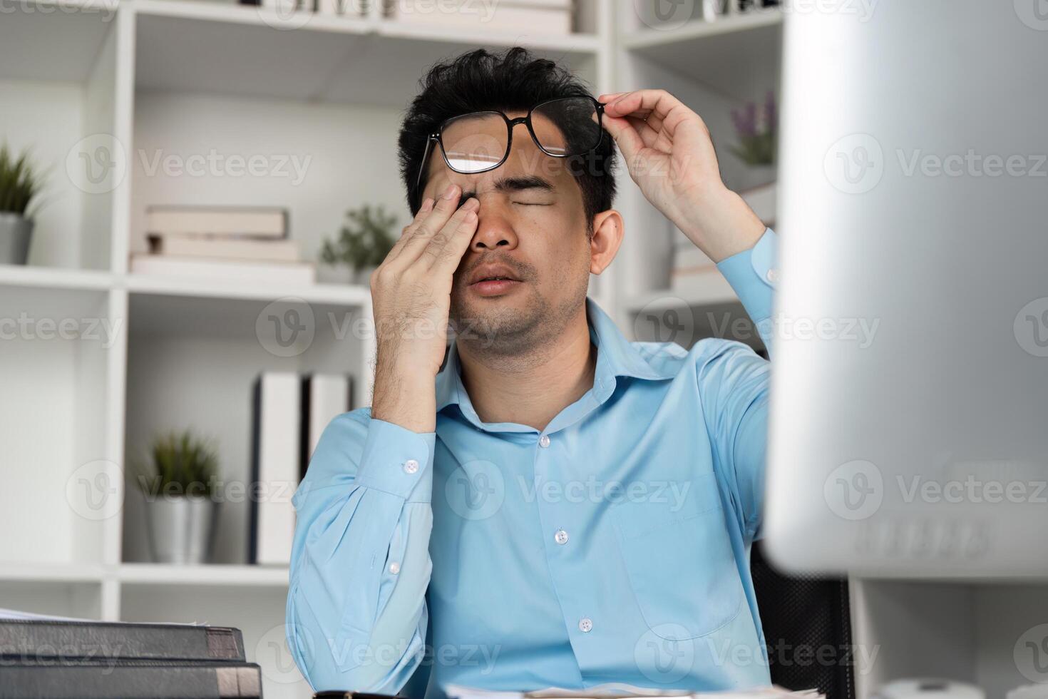 Tired professional struggles with hard work at office desk workspace stressful environment close-up view photo