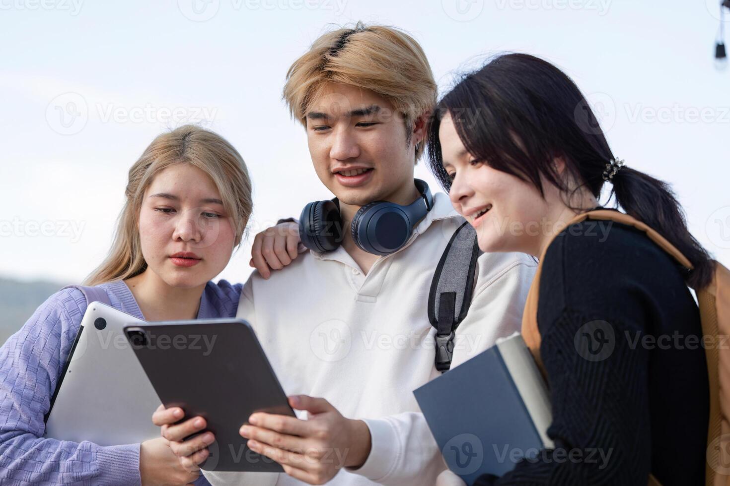 Diverse Group of Students Engaged in Online Learning Outdoors with Laptops and Tablets photo