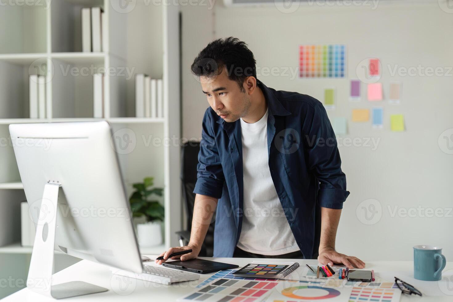 Creative Graphic Designer Working in Modern Design Studio with Digital Tools and Color Samples photo