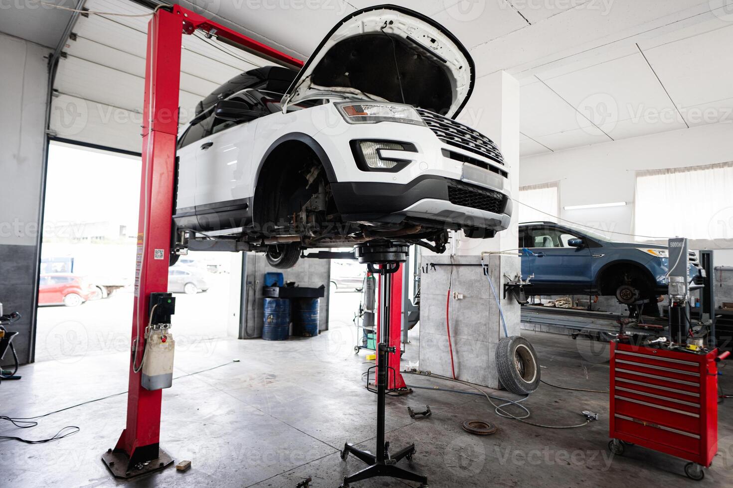 Car maintenance in professional auto repair workshop with lift photo