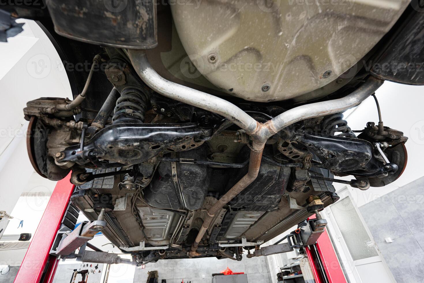 Car underside view in a modern auto repair shop photo