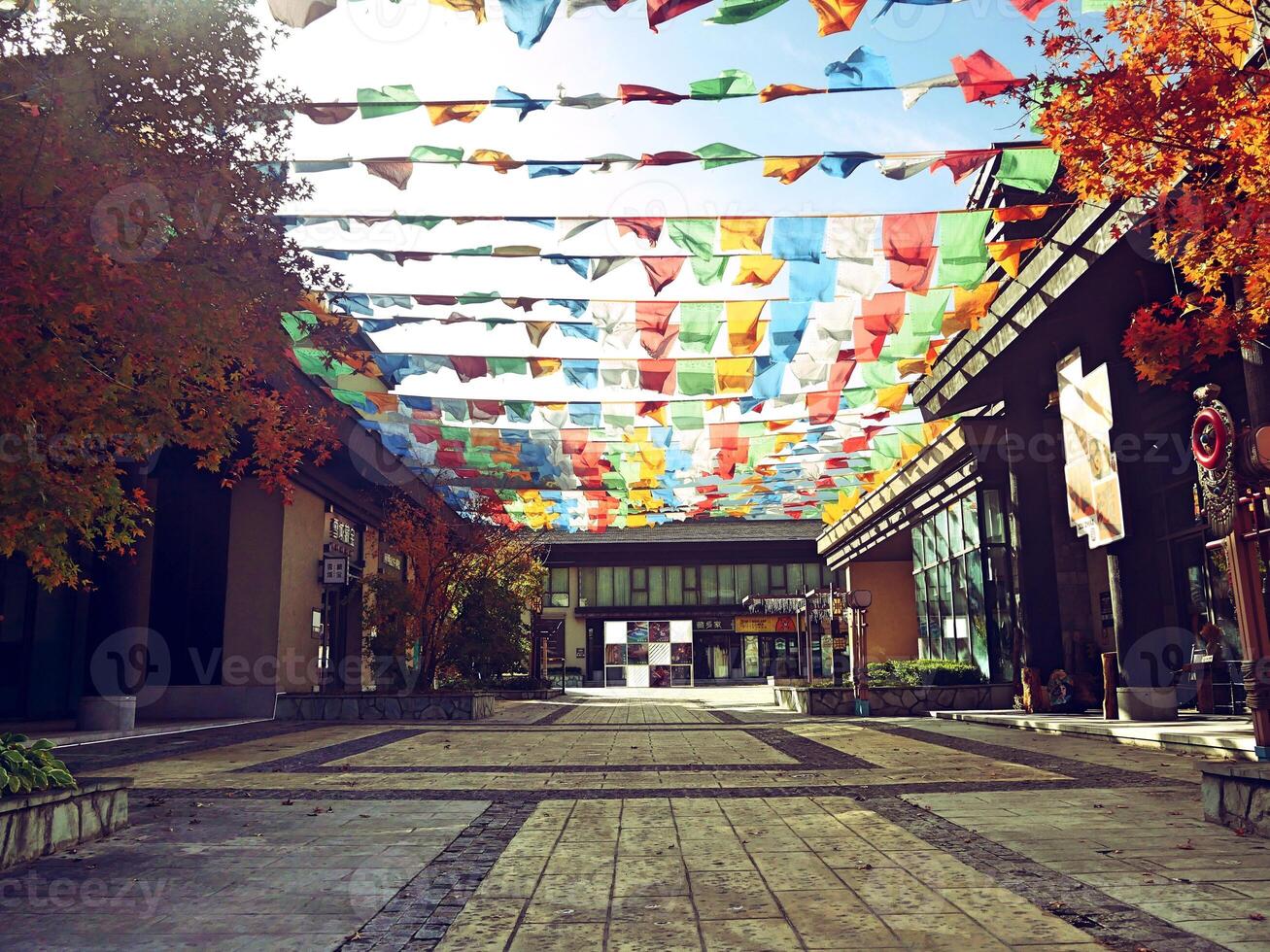 a street with many colorful flags hanging from the ceiling photo