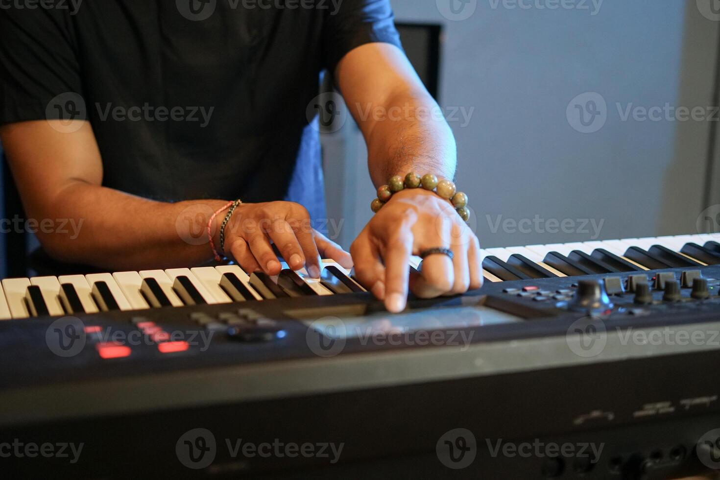 Musician playing music keyboard, Close up of Asian man hand in black shirt playing piano and practicing in home studio photo