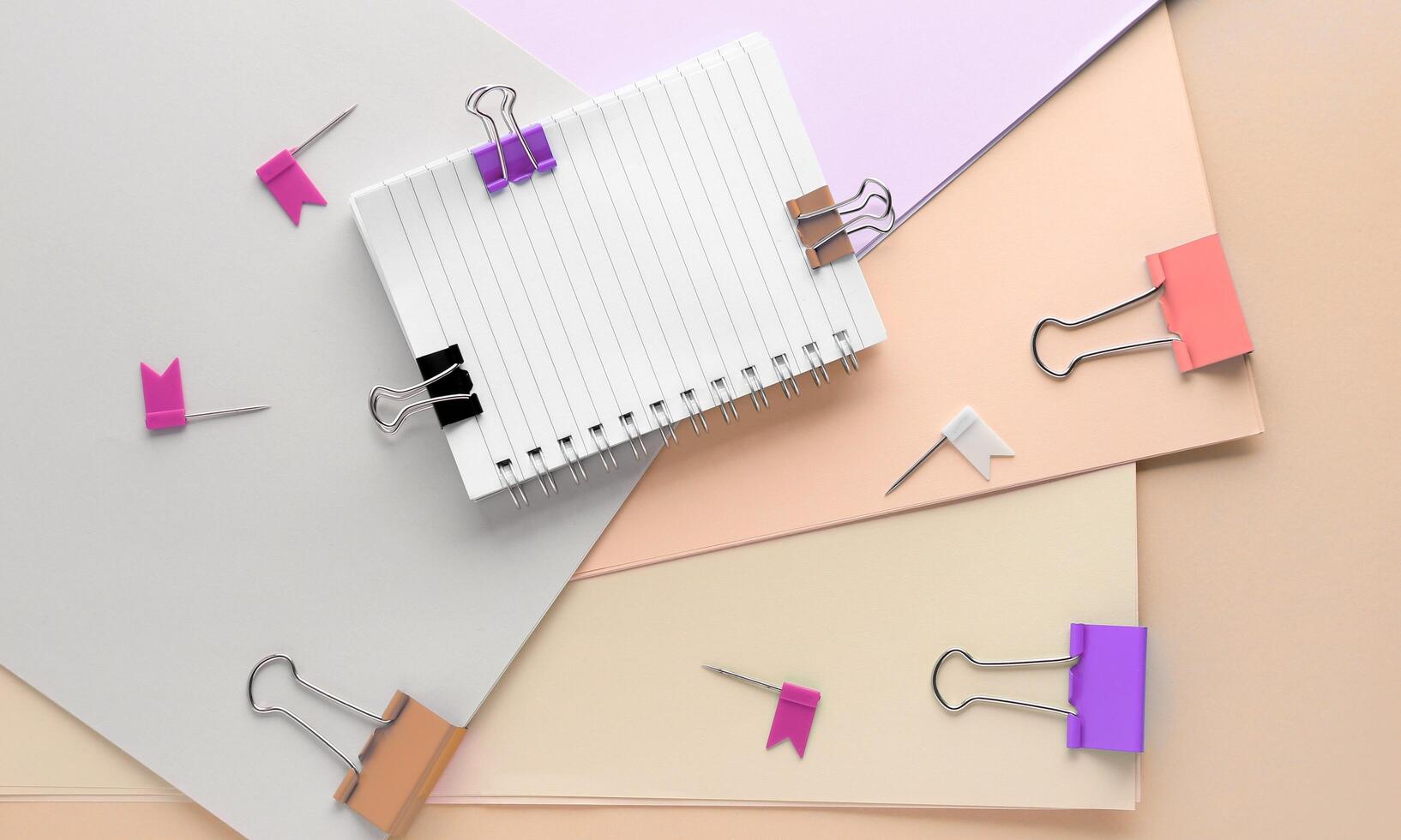 Paper clips and notepads on a beige background photo