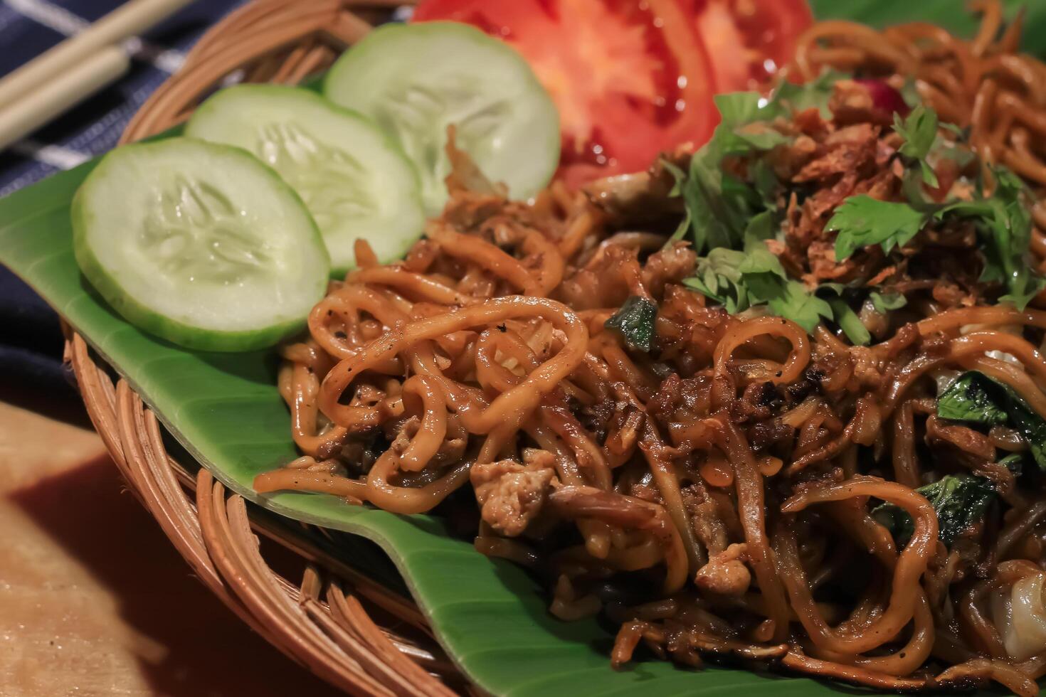 Fried noodles served on a plate. Fried noodles consist of noodles, cucumber, meat, egg, tomato. Fried noodles are a popular food in Asia photo