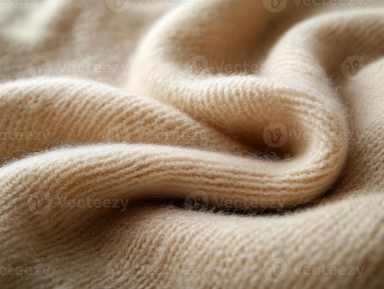 Beige knitted wool fabric texture forming soft folds, warm and cozy background photo