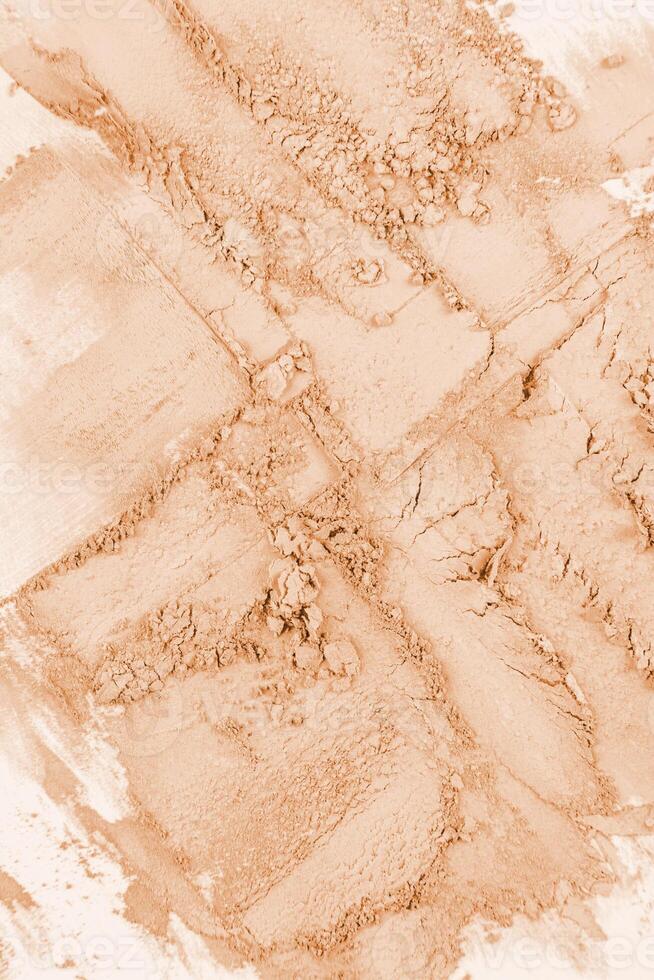 Abstract beige dry powder background. chaotic brushstrokes of cosmetic texture. vertical top view. Mockup for product advertisement, powder texture. photo