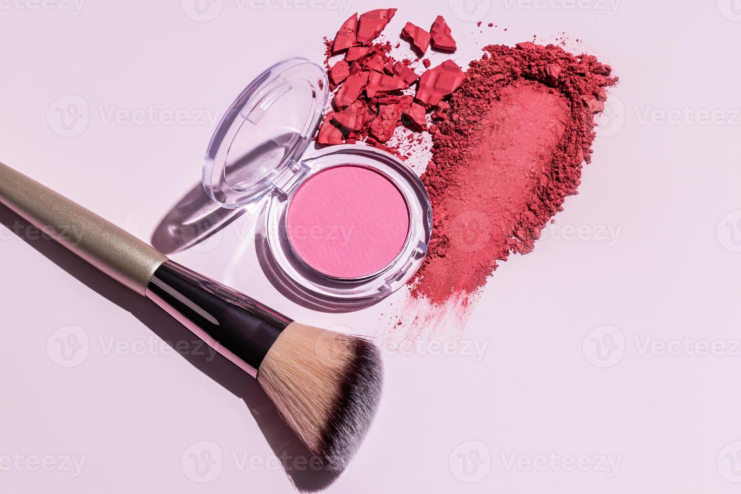 A sample of pink blush, an open pack of soft pink blush, a makeup brush on a light background. texture of decorative cosmetics. The concept of beauty. photo