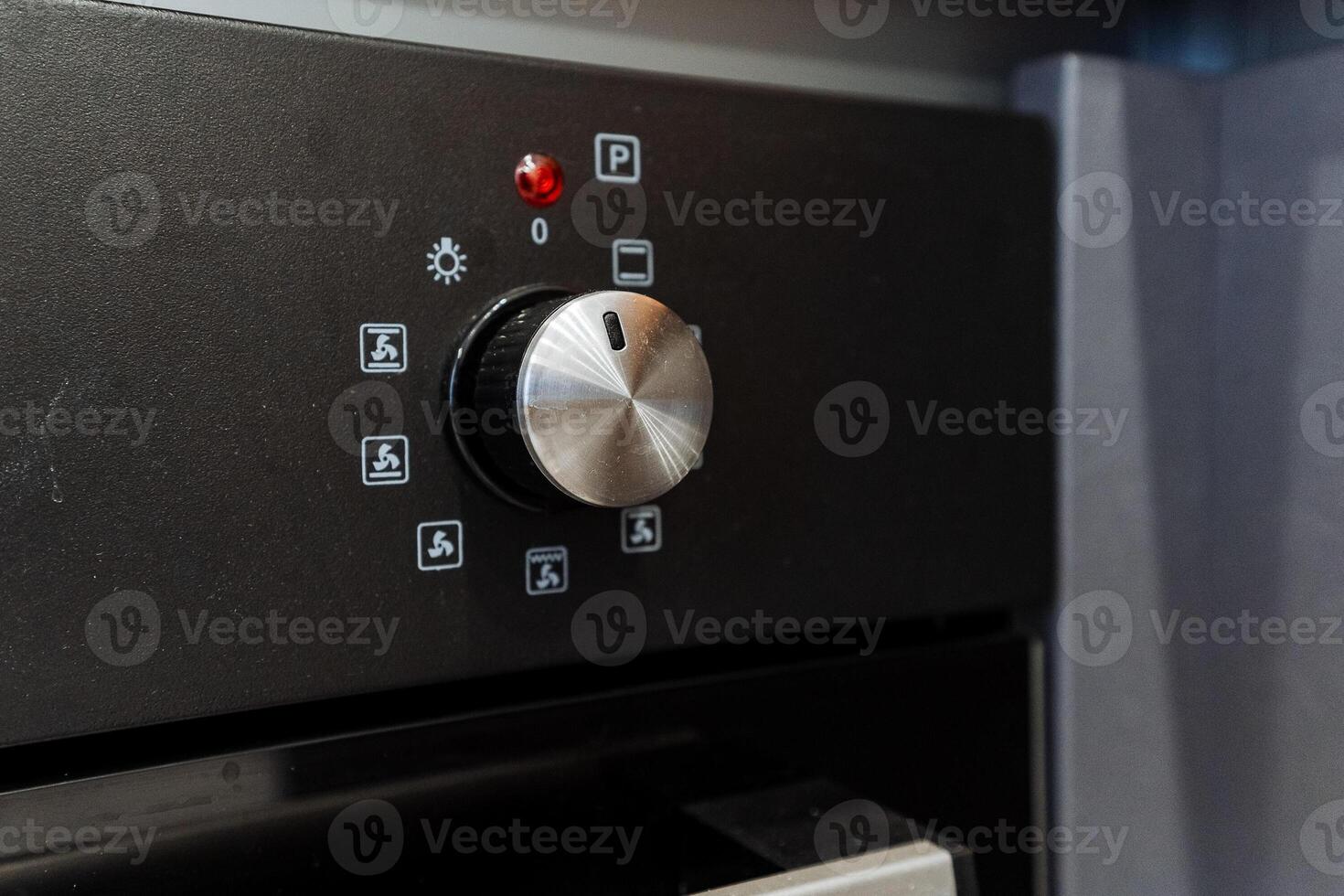 Home appliance Close up of black oven with silver knob and buttons photo
