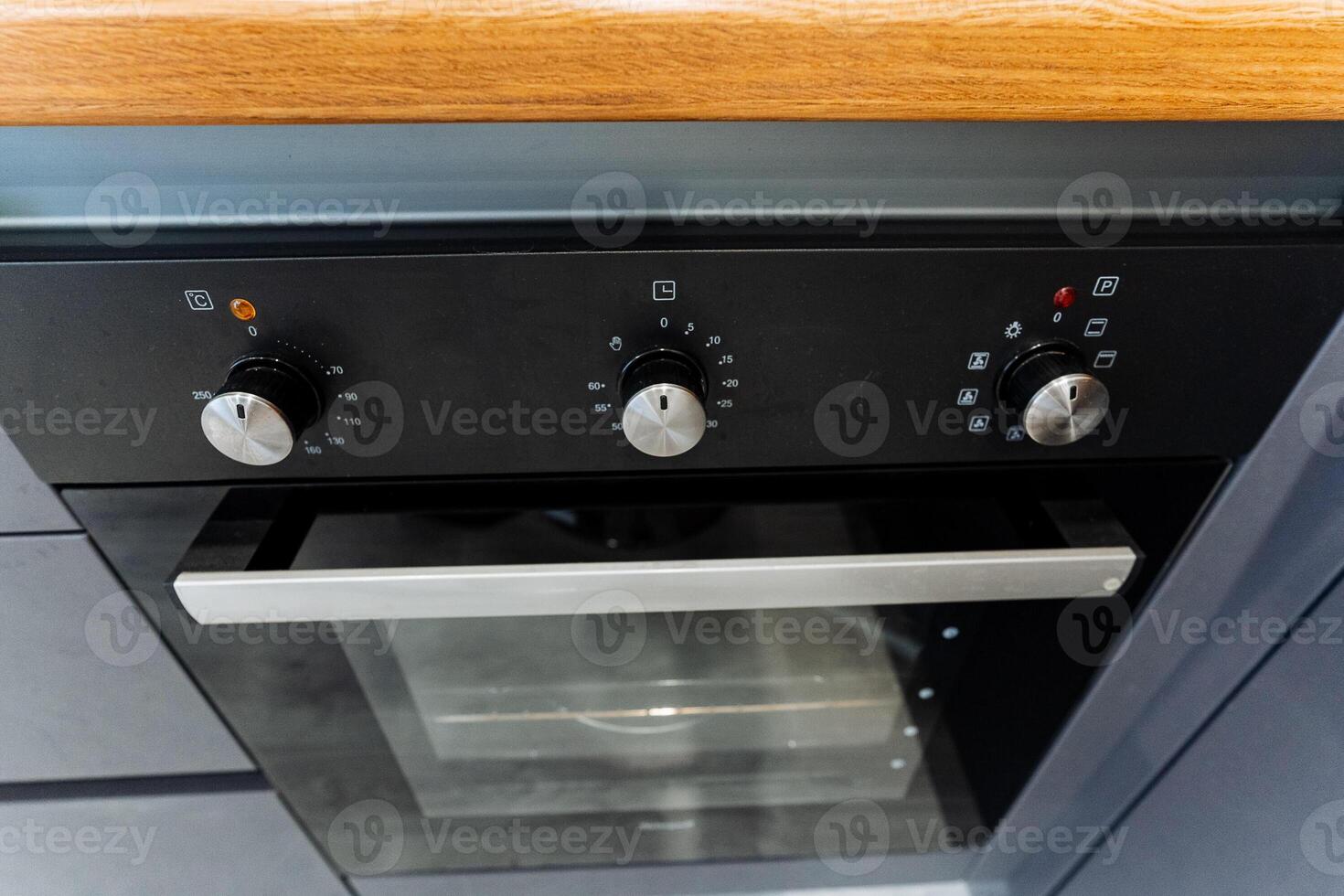 A black oven sits on a wooden counter in a kitchen photo