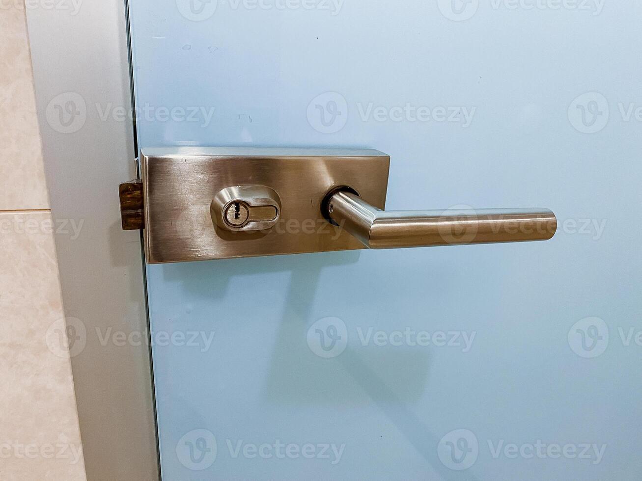 Close-up view of a stainless steel door handle, a fixture typically used on wood or metal doors, with a dead bolt and latch lock. photo