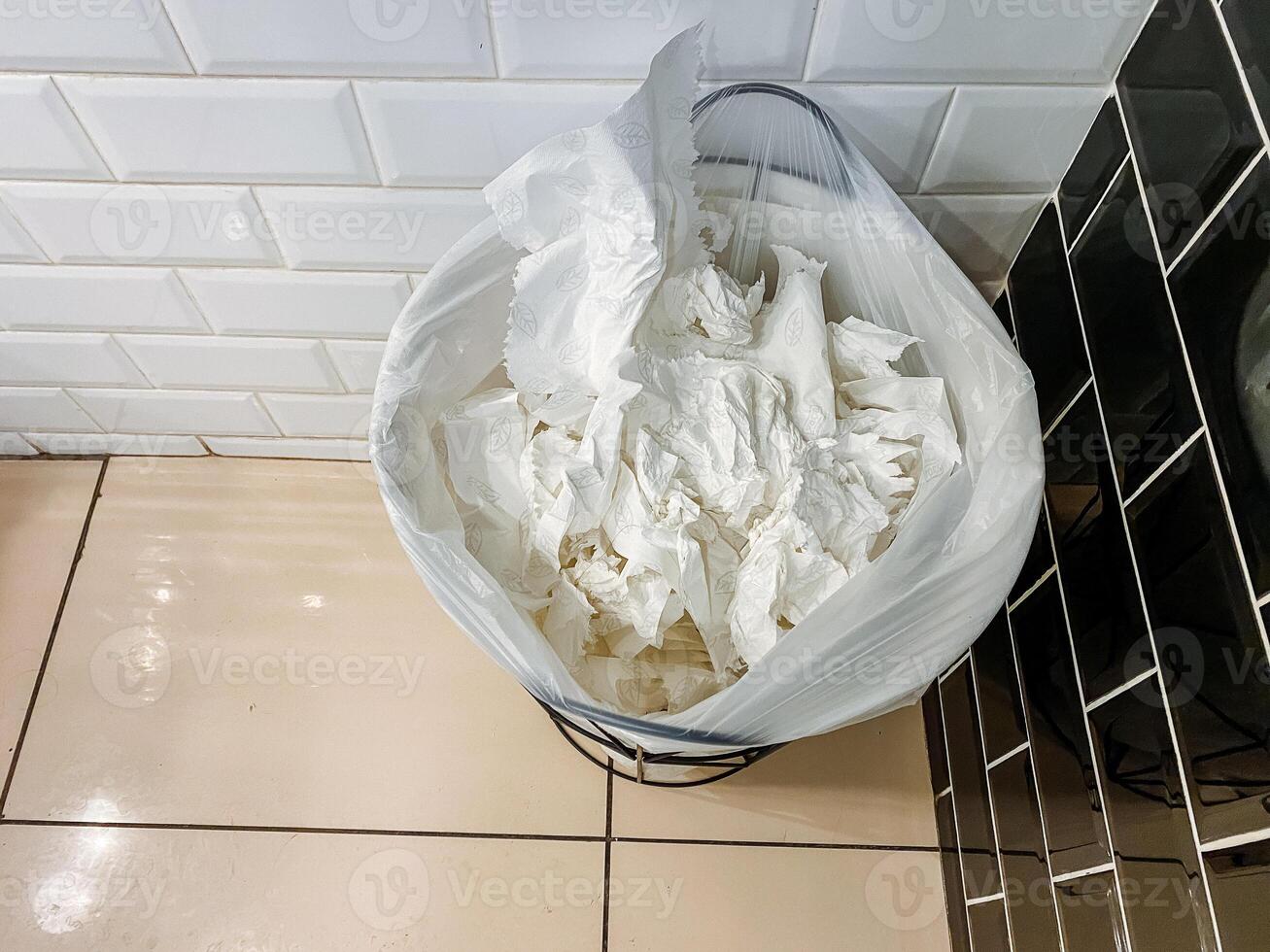 Bathroom trashcan filled with used tissues is not related to food, recipe, ingredient, kitchen appliance, cuisine, dish, dairy, cream, buttercream, or major appliance. photo