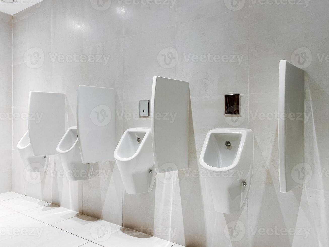 Row of urinals in a restroom, plumbing fixtures made of glass and wood photo