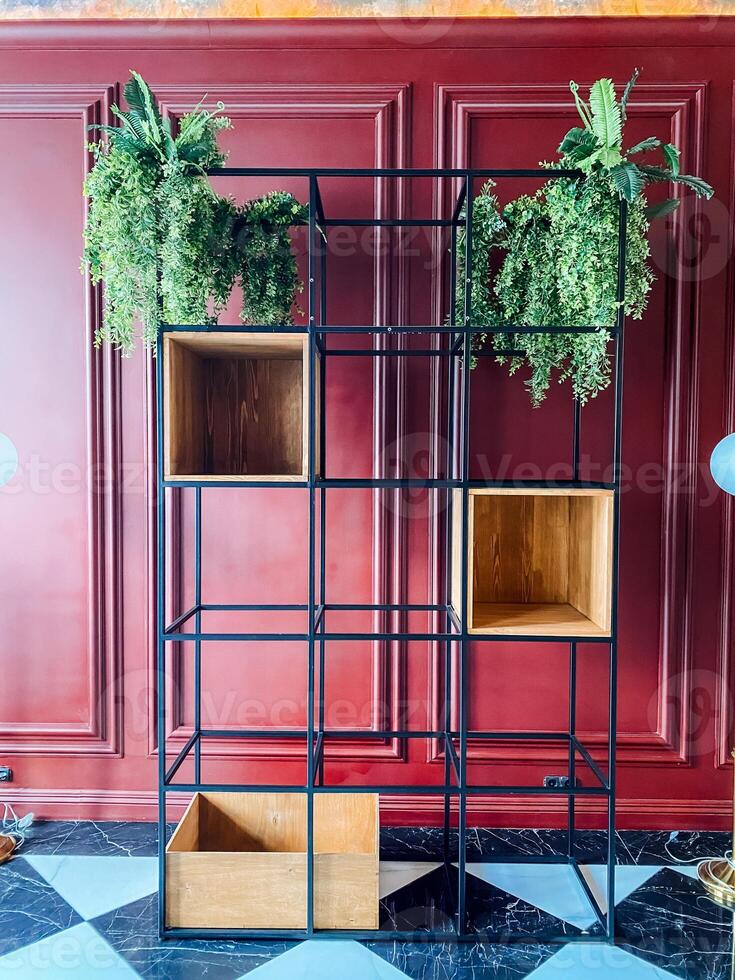 A rectangular wooden shelf with plants in front of a yellow building facade photo