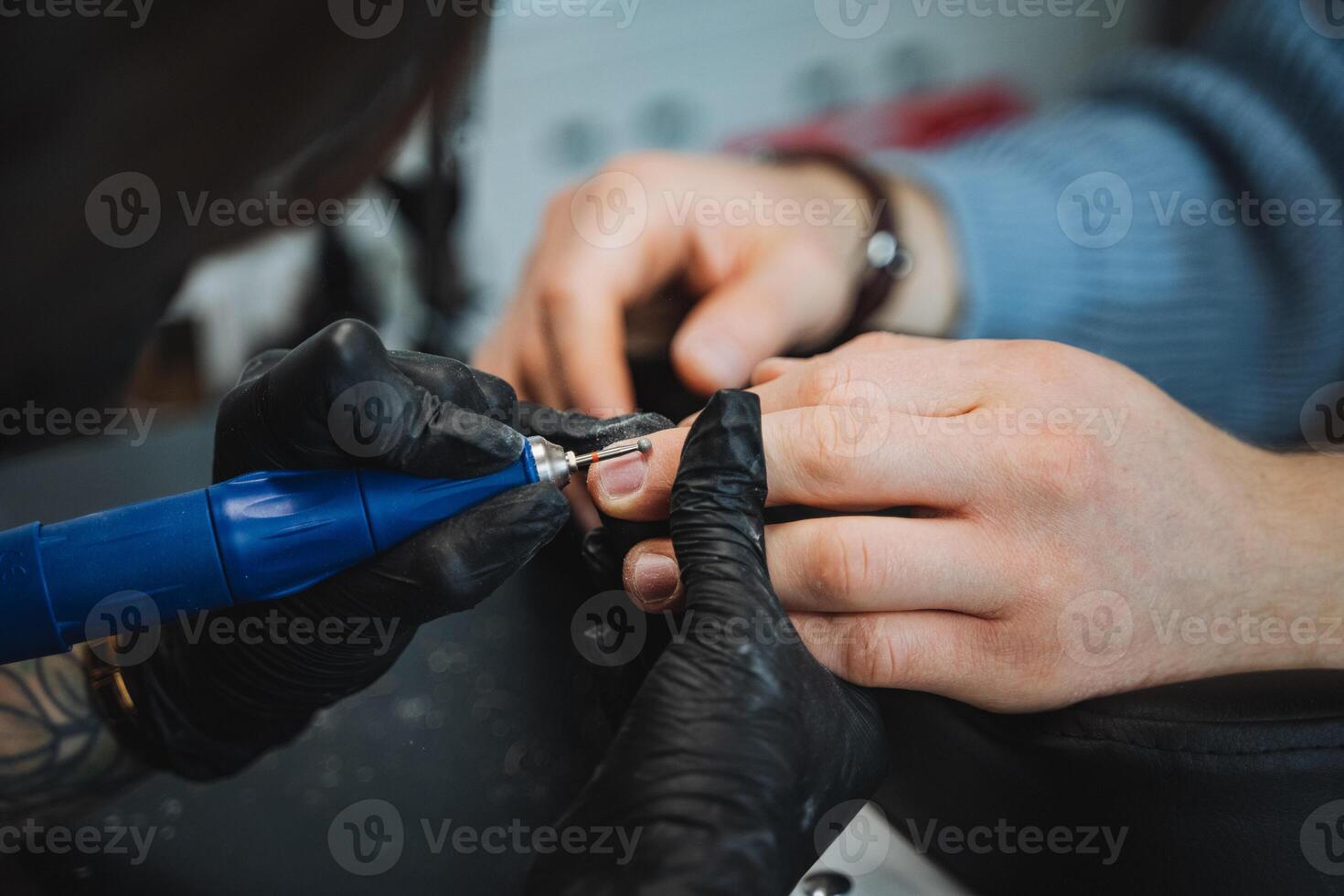 Detailed closeup of a manicure procedure at a modern nail salon where a professional manicurist focuses on grooming the clients nails with precision and pampering care photo