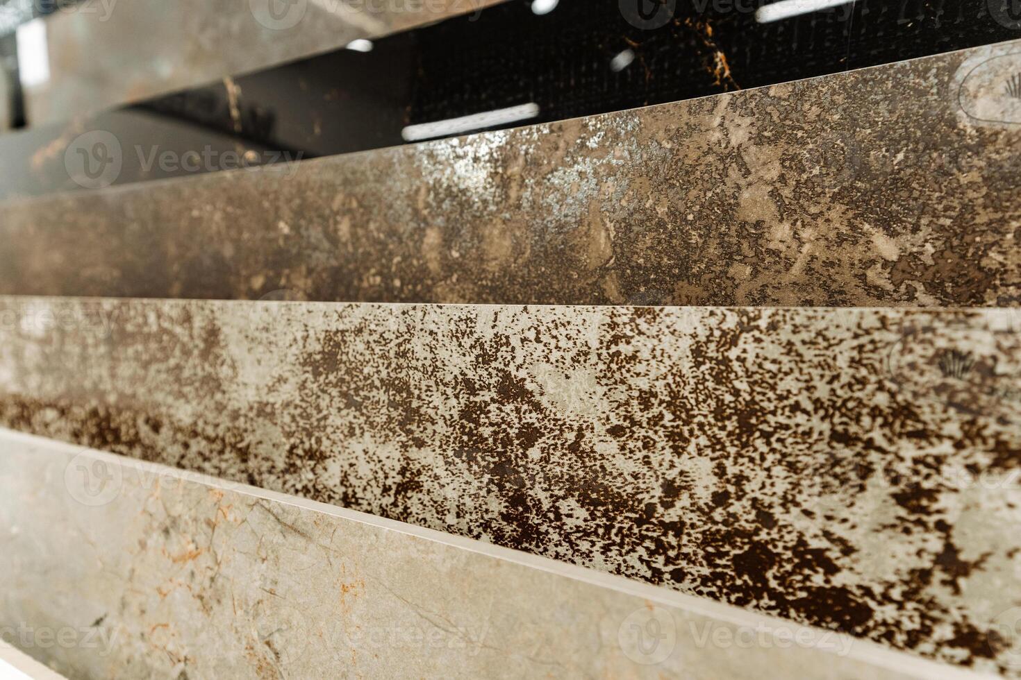 The photograph displays various stains on a marble countertop, possibly from substances such as automotive tires, wood, and asphalt, creating a detailed view of the damage photo