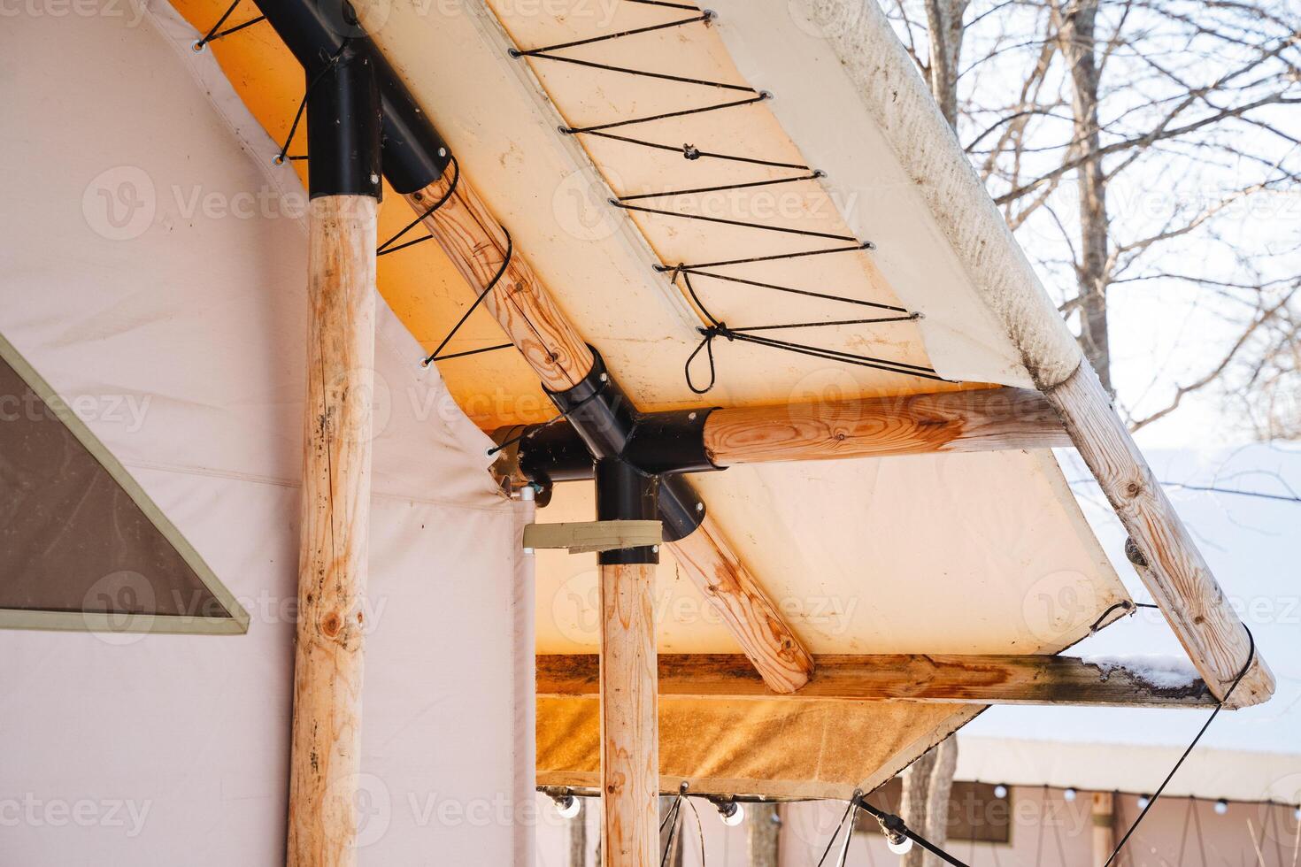 The upper section of the tent is constructed from robust wood and resilient canvas, providing outstanding structural support and dependable protection against various weather conditions photo
