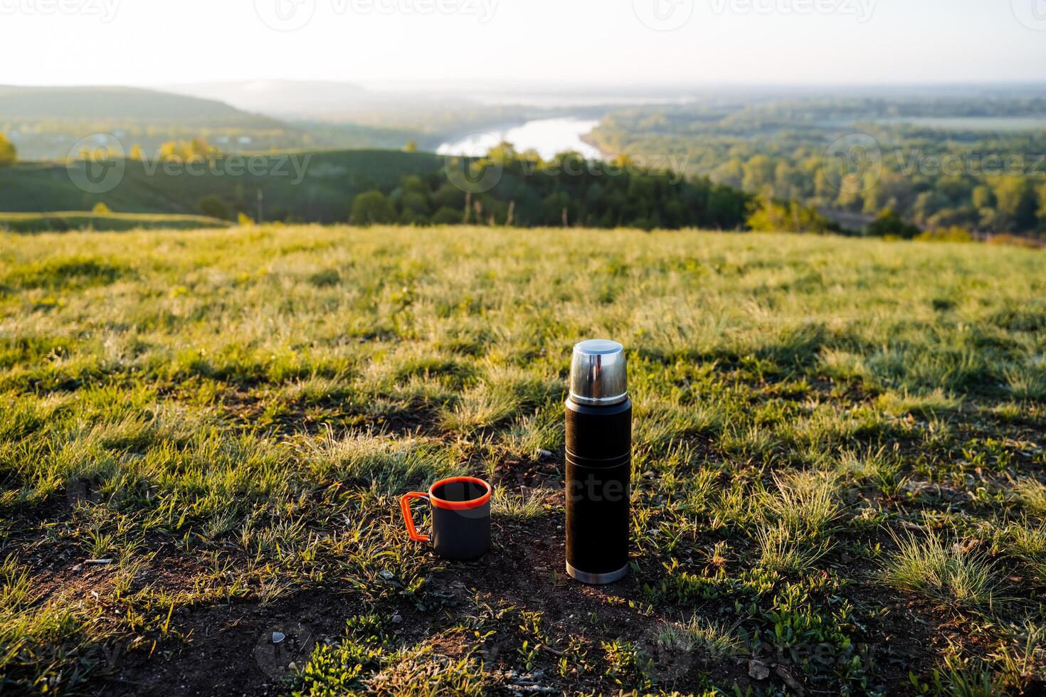Morning Coffee Outdoors Thermos and Cup on Scenic Hillside photo