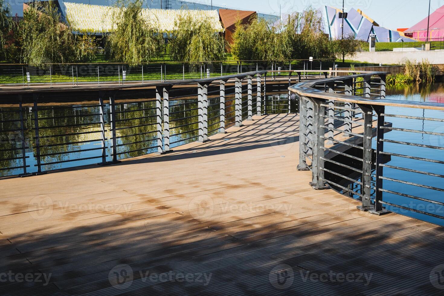 A wellconstructed bridge elegantly spanning over a picturesque body of water situated within a beautifully maintained park, providing a scenic view and pleasant experience for visitors photo