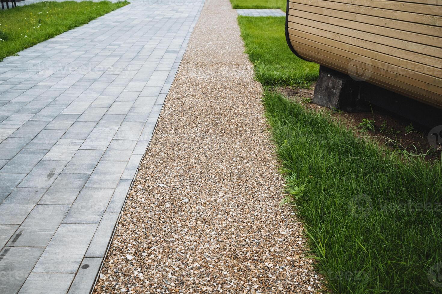 The walkway design is wellthoughtout, combining various elements like brick, gravel, and grass to accentuate important elements and elevate the overall appeal of the outdoor area photo