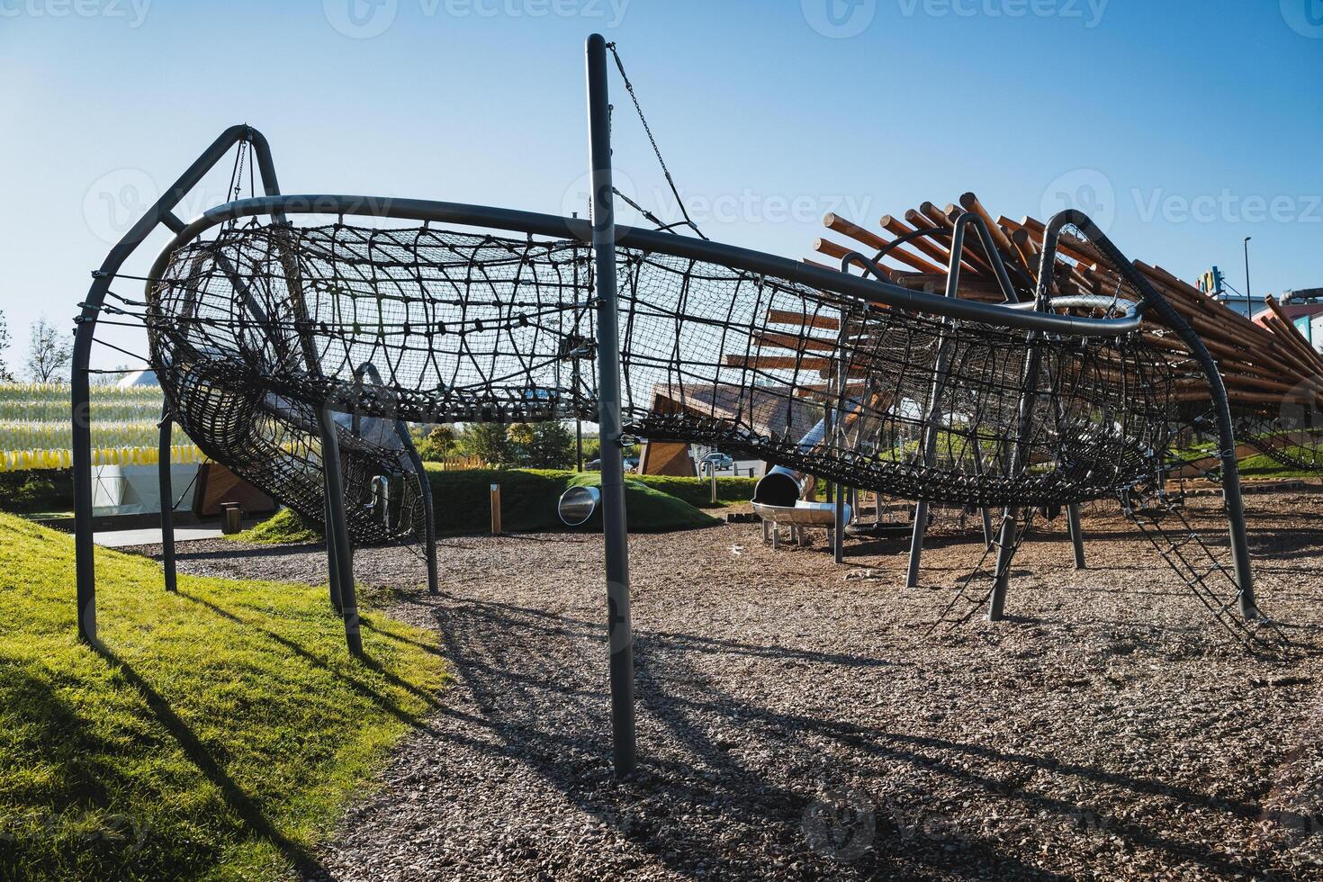 A lively playground featuring a fun slide as well as an exciting ropes course situated in a beautiful park that is ideal for recreational activities and leisure time enjoyment photo