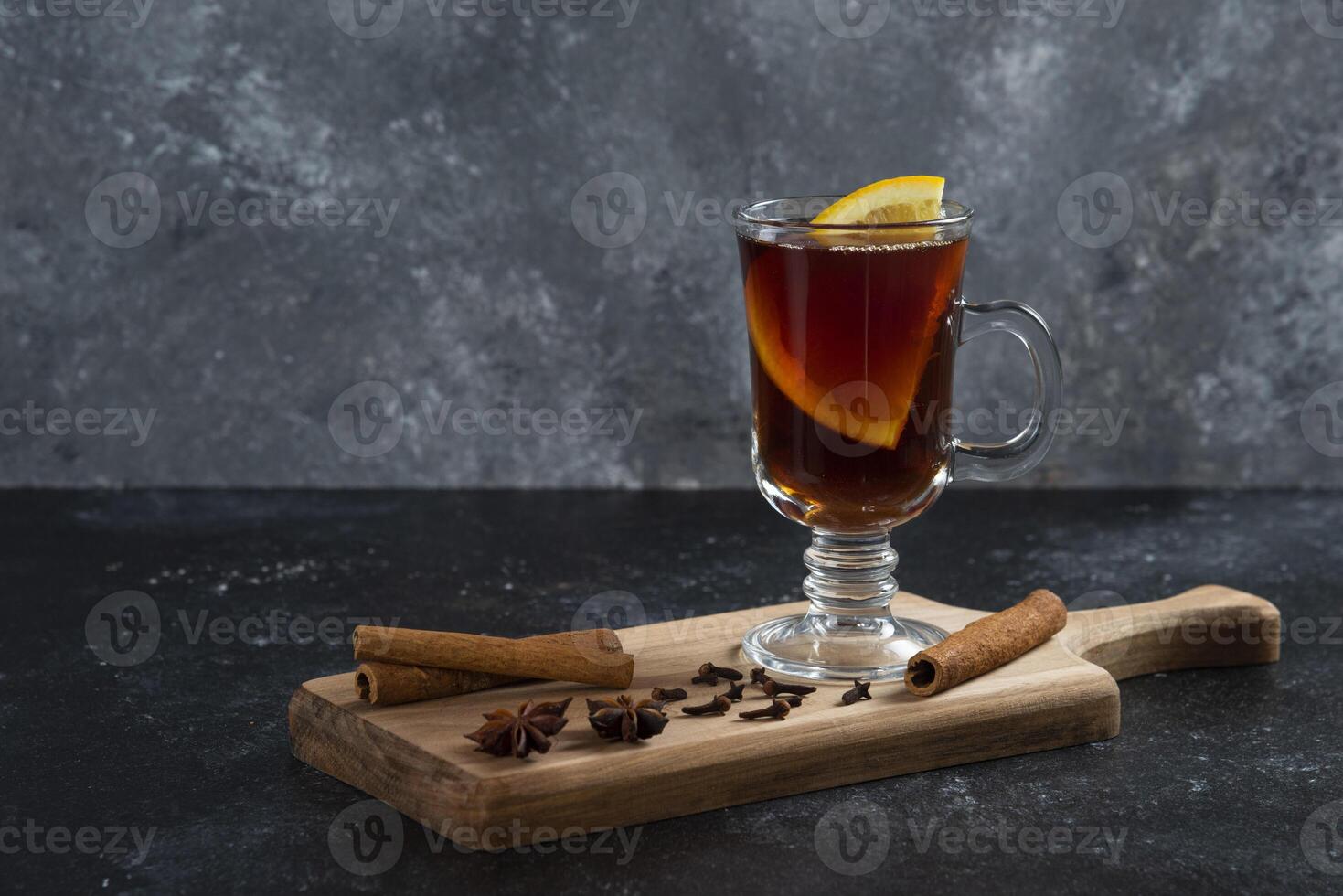 a glass of hot drink with cinnamon and an orange slice photo