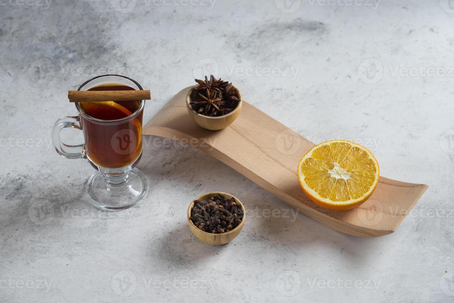 A cup of tea with slice of orange and dried loose teas photo