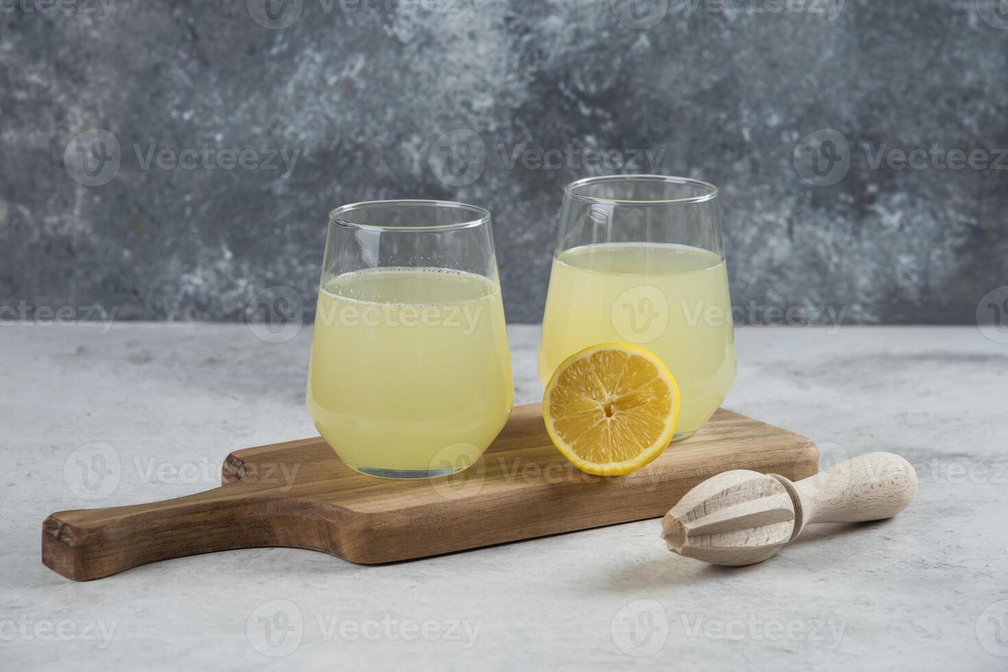 two glasses of lemonade with a wooden cutting board photo