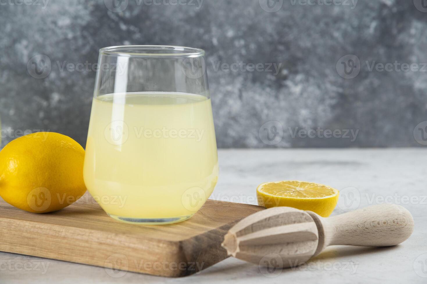 A glass cup of lemonade and wooden reamer photo