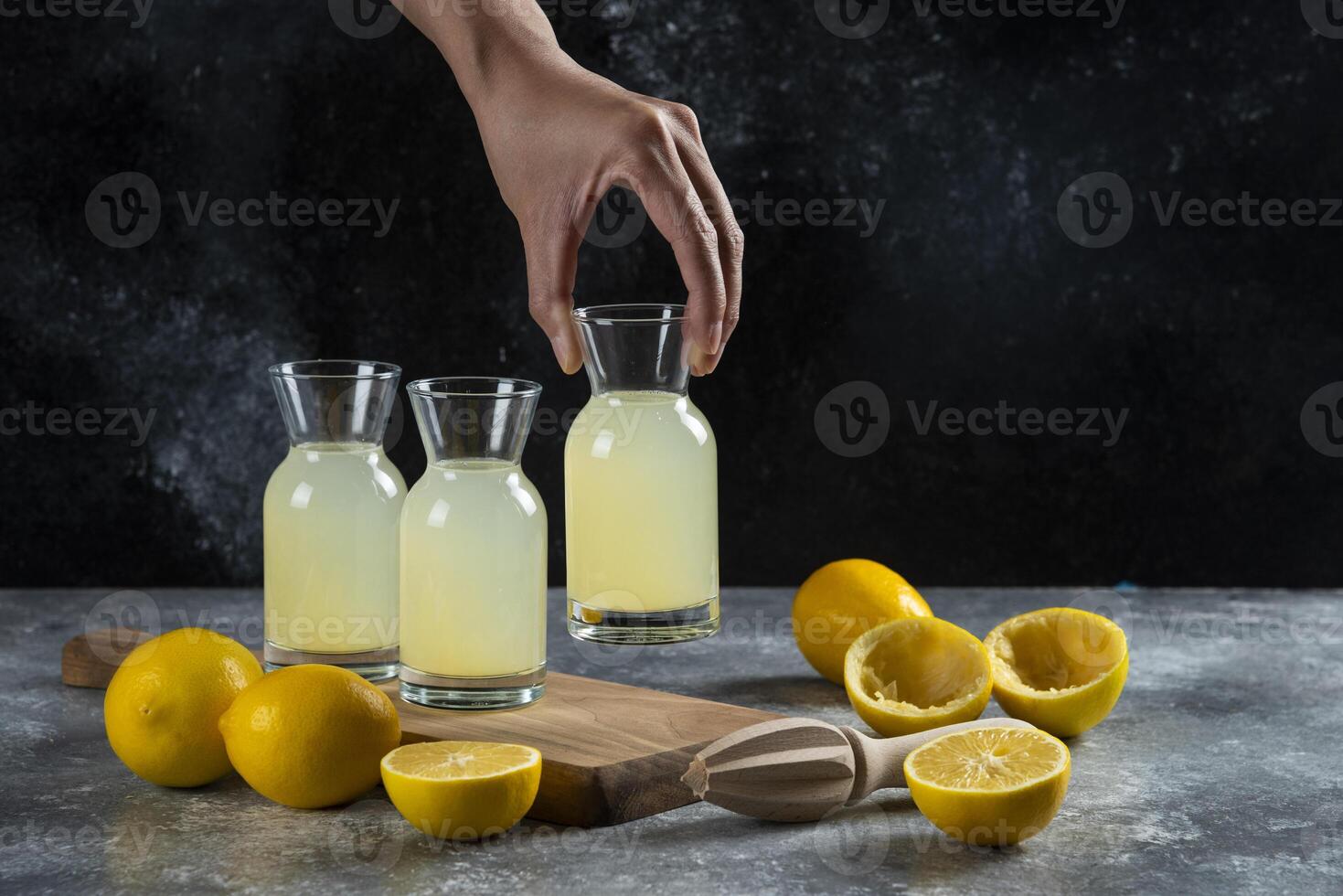 A hand taking a jar of lemon juice photo