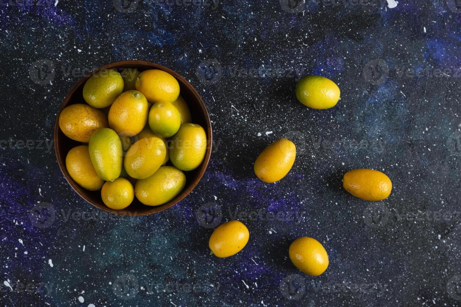 Top view of kumquats in wooden bowl photo