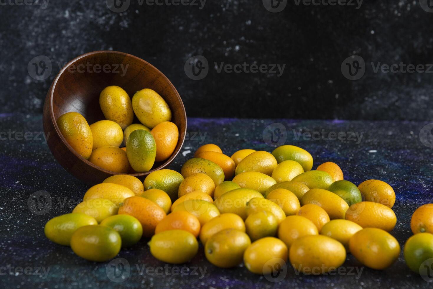 Pile of fresh juice kumquats on blue background photo