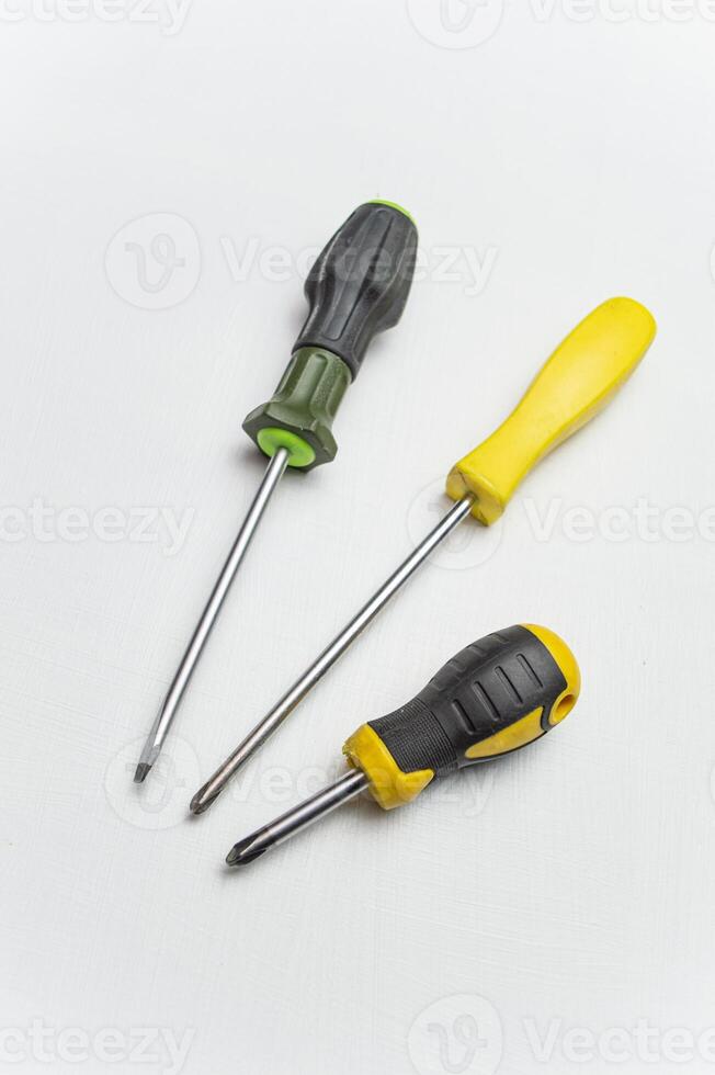 Different old screwdrivers on a white background. Cross, minus and with a rubber handle against electric shock. High quality photo
