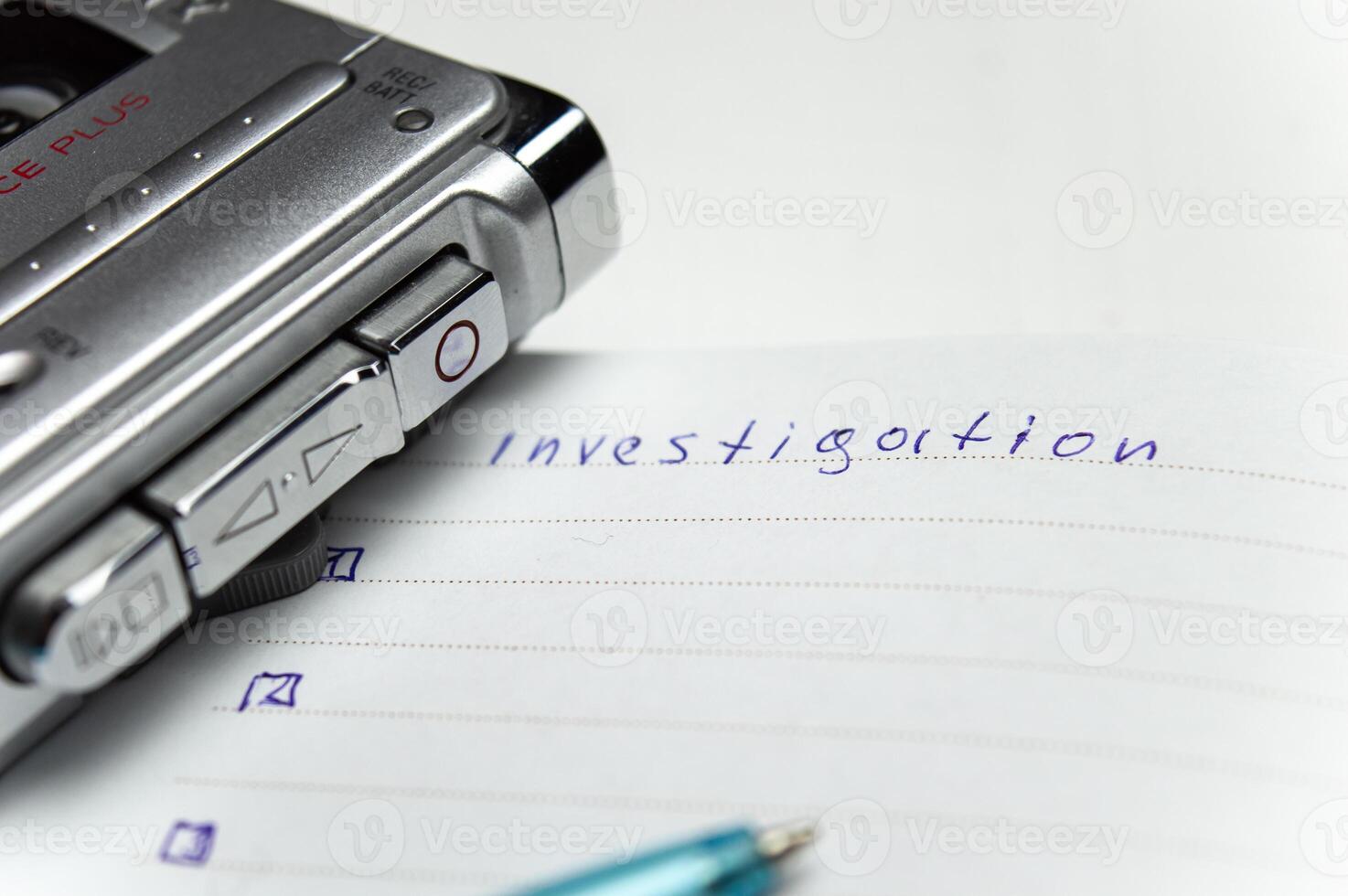 A tape recorder with buttons is on a notebook labeled investigation. the white background and workspace of the student detective professor. High quality photo