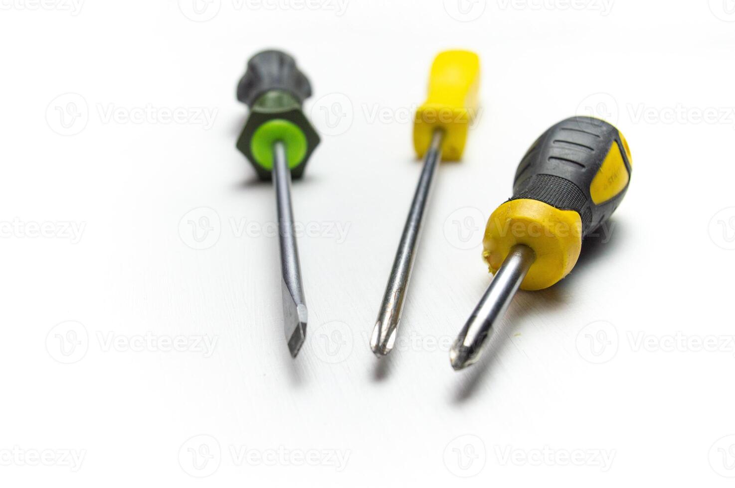 Different old screwdrivers on a white background. Cross, minus and with a rubber handle against electric shock. High quality photo