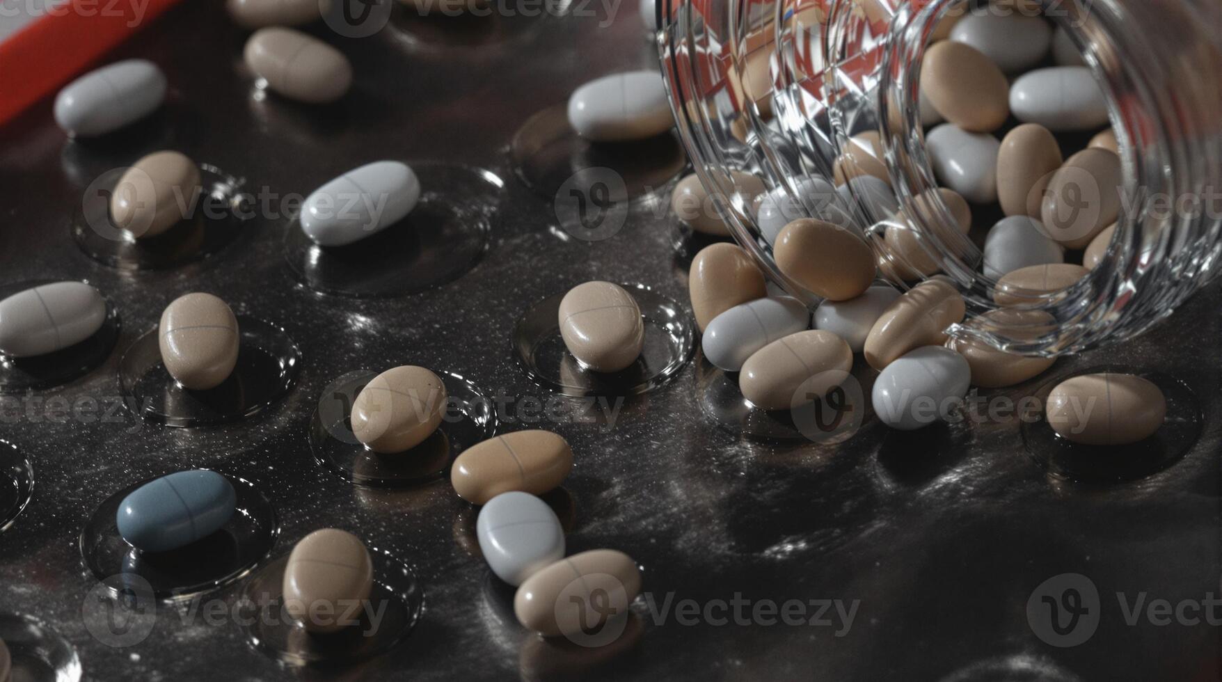 A beautiful array of colorful beans has spilled out from a jar onto a dark surface photo
