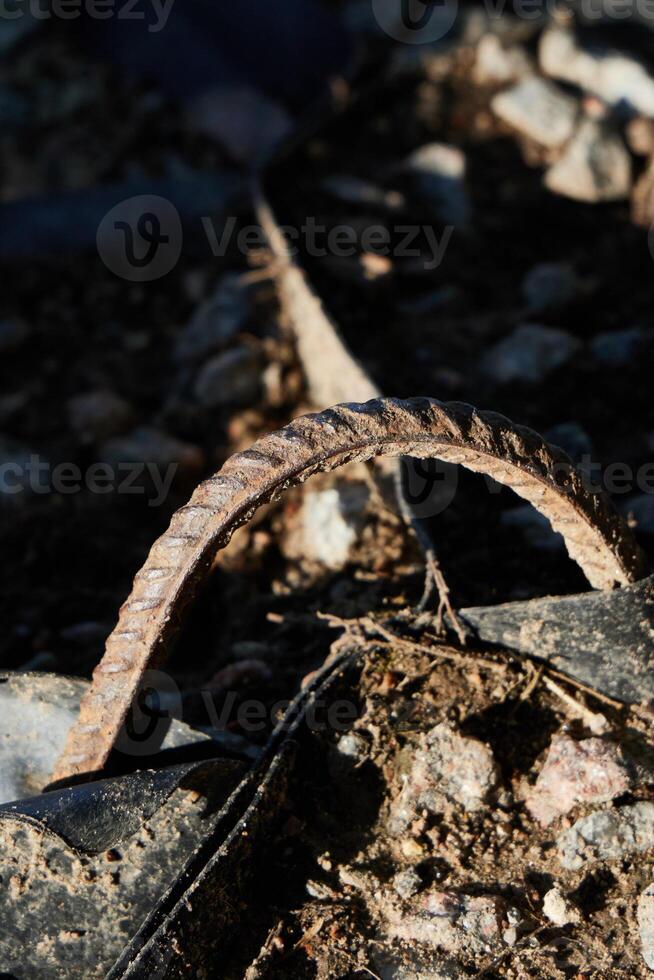 A piece of rusted rebar is surrounded by a mixture of gravel and soil in the landscape photo