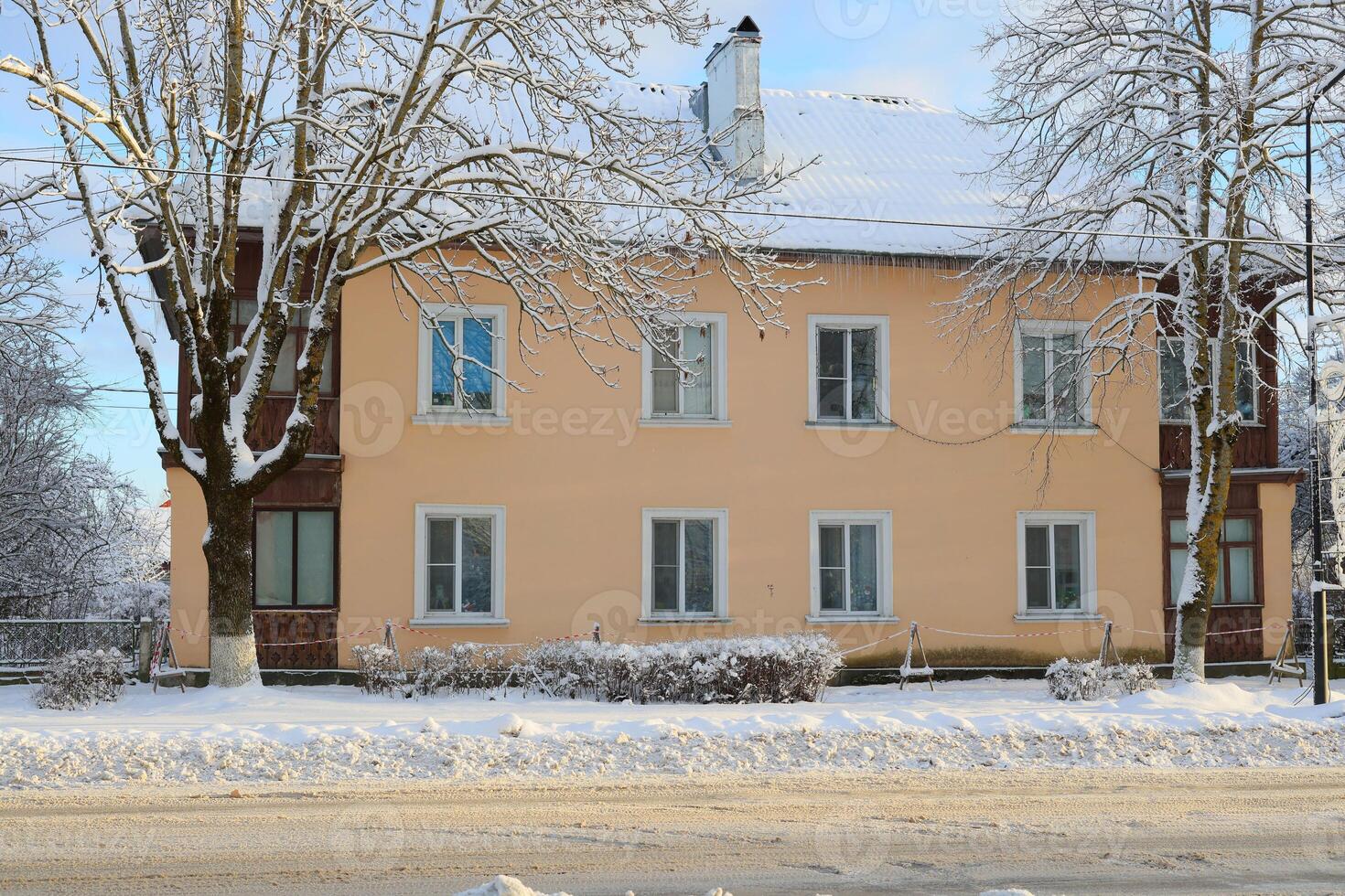 A beautiful winter landscape depicting a snowcovered building surrounded by serene trees photo