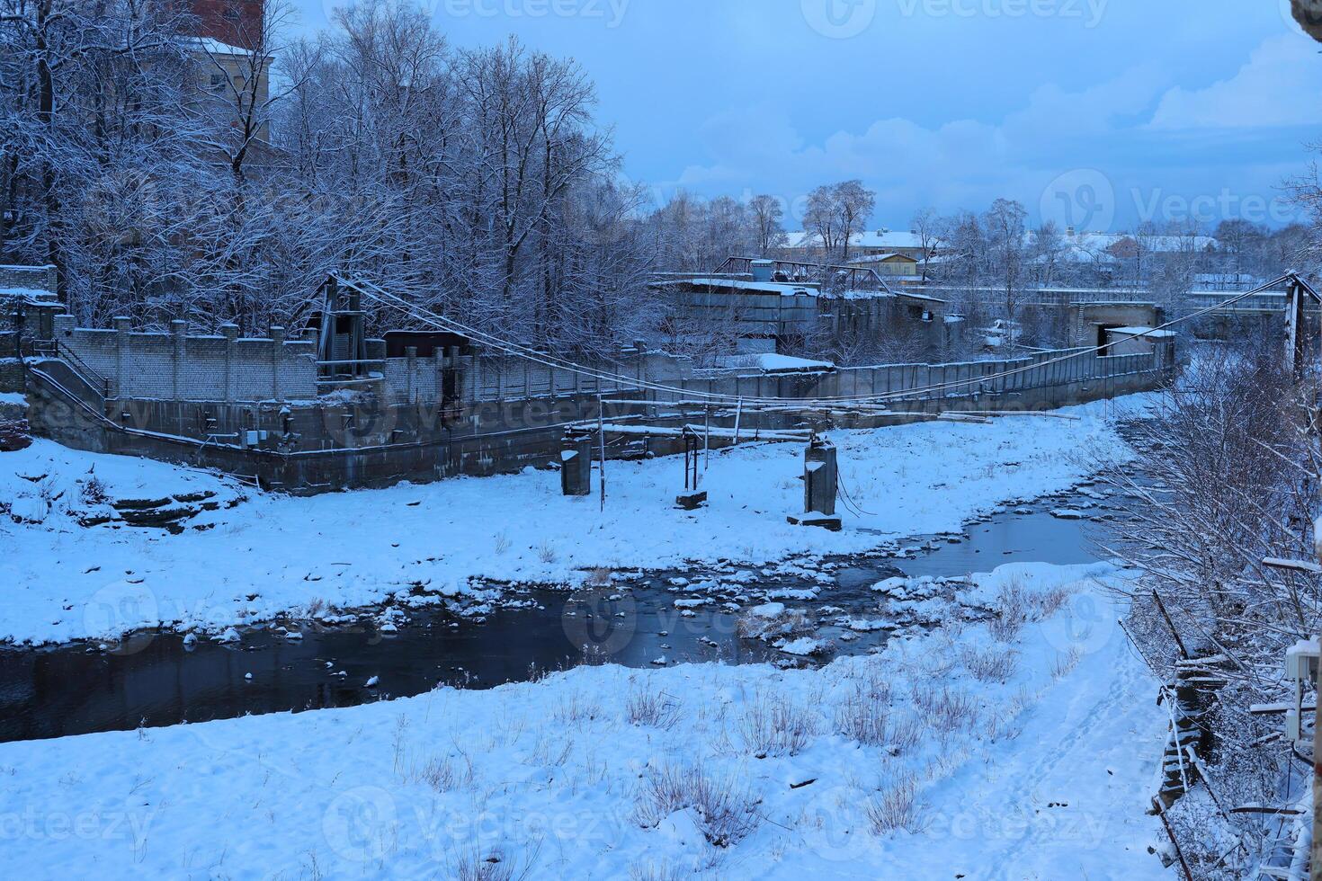 A stunning winter landscape with a snowcovered river, creating a serene atmosphere photo