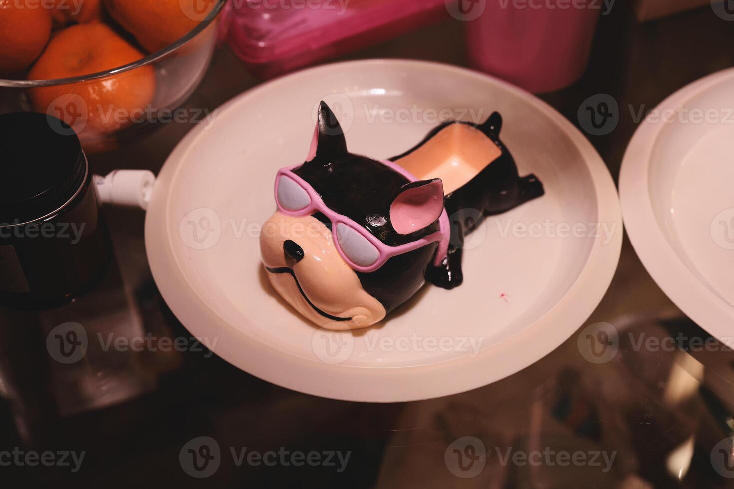 Adorable Cute Black Dog Figurine Wearing Sunglasses Placed on a Decorative Plate photo