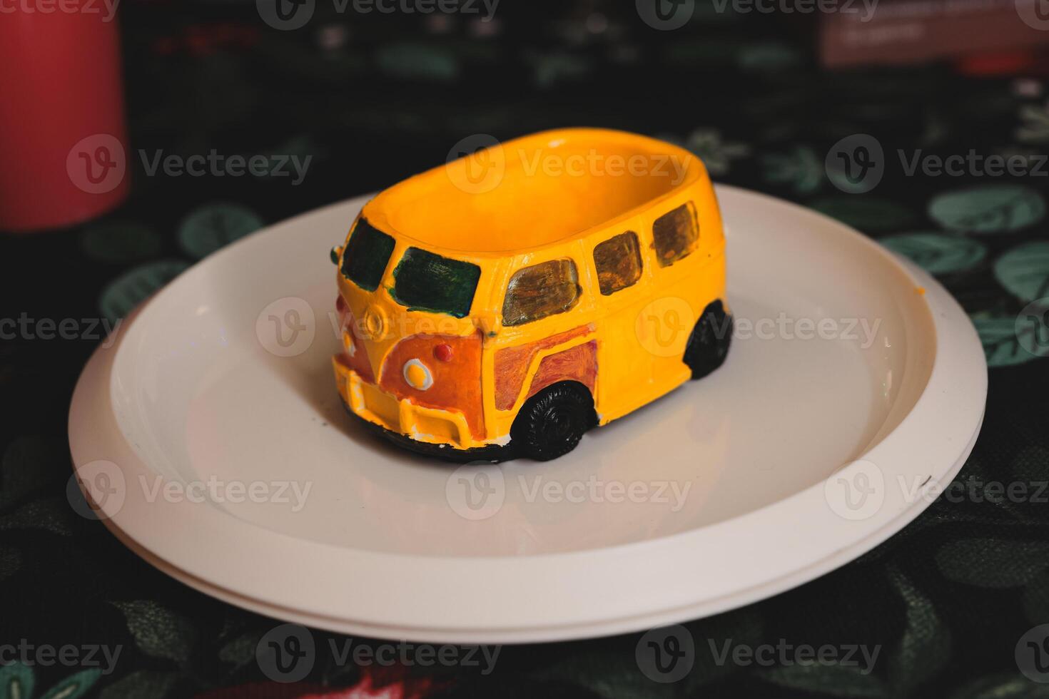 A Delightfully Colorful Miniature Dessert Shaped Like a Car, Elegantly Placed on a Decorative Plate photo